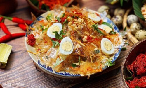 Bát bánh tráng trộn đầy đủ topping khô bò, xoài bào sợi, trứng cút, rau răm, rắc đậu phộng và chan nước sốt đậm đà chuẩn vị tại nhà