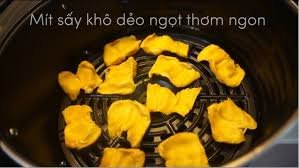 Xếp mít lên khay lò nướng trong bước sấy của cách làm mít sấy